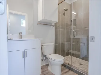 a bathroom with a shower a toilet and sink