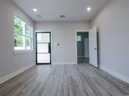 an empty room with wooden floor and windows