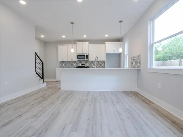 a view of a kitchen with a sink and wooden floor