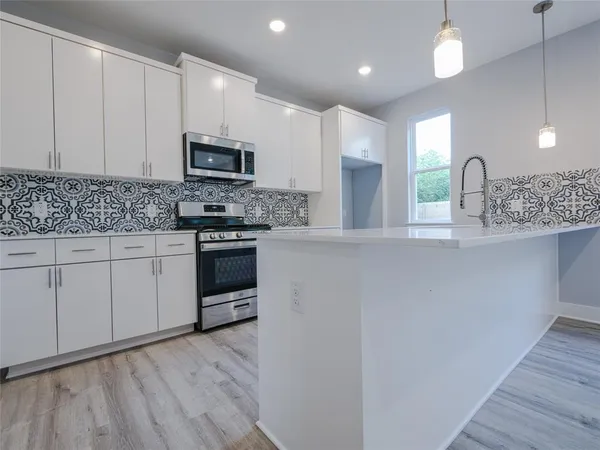 a kitchen with stainless steel appliances granite countertop a stove a sink and a refrigerator