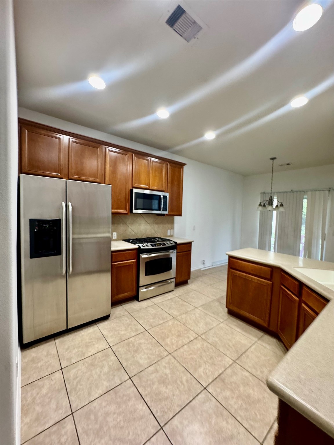 13600 Breton Ridge Street, Unit 36C Houston, TX 77070 - Photo 28 of 40 a kitchen with stainless steel appliances a sink a stove a microwave a refrigerator and cabinets