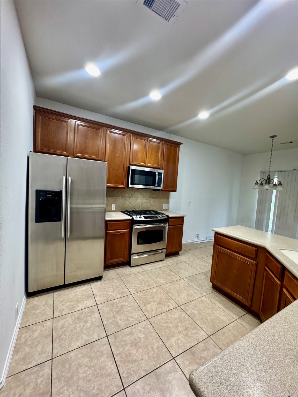 13600 Breton Ridge Street, Unit 36C Houston, TX 77070 - Photo 37 of 40 a kitchen with stainless steel appliances granite countertop a stove a sink and a microwave