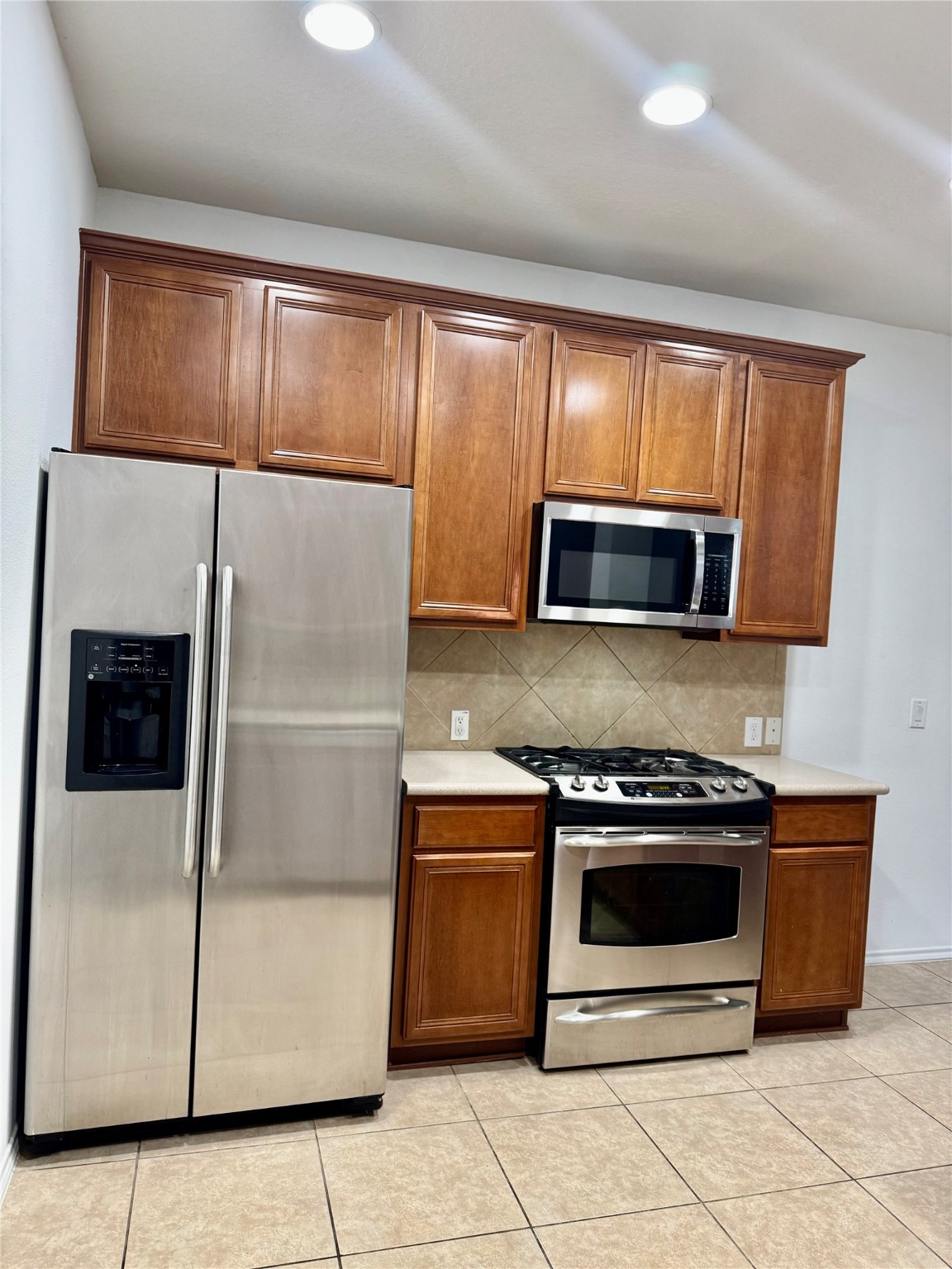 13600 Breton Ridge Street, Unit 36C Houston, TX 77070 - Photo 39 of 40 a kitchen with a stove microwave and refrigerator