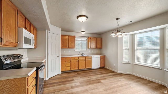 983 South 1850th Street West Springville, UT 84663 - Photo 7 of 30 Kitchen featuring wood-finish flooring, natural wood cabinetry, a white microwave, a black electric range, and a white dishwasher