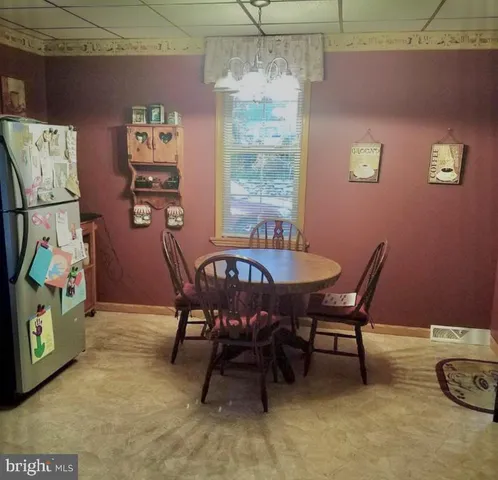 a view of a kitchen with fridge and wooden floor