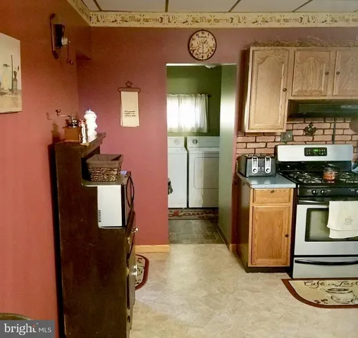 a kitchen with stainless steel appliances granite countertop a refrigerator a stove top oven a sink and dishwasher