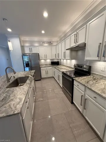 a kitchen with a sink a stove and cabinets