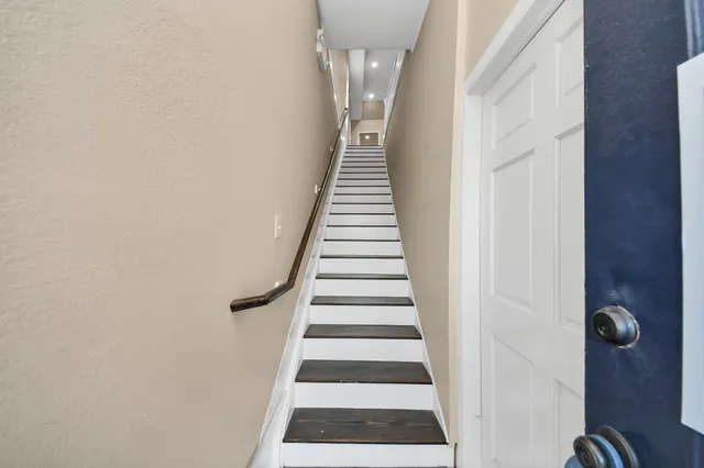 a view of a hallway with entryway and wooden floor