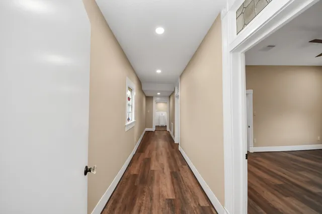 a view of a hallway with wooden floor and staircase