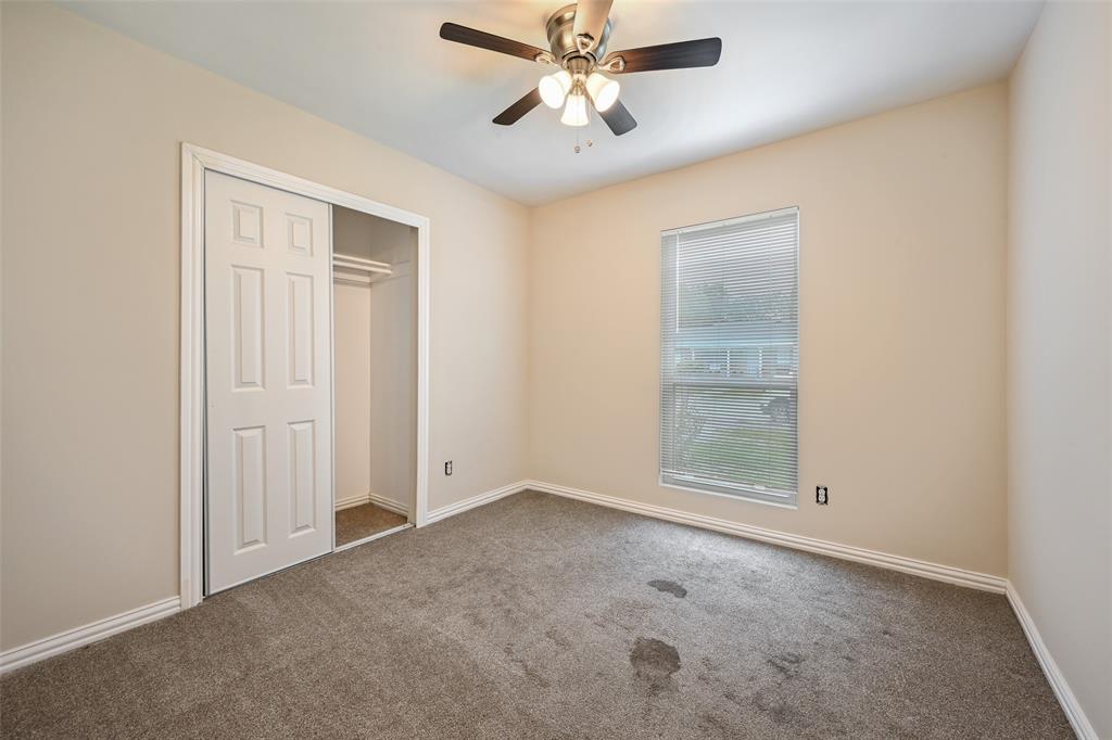 7318 Emory Oak Lane Dallas, TX 75249 - Photo 25 of 28 Neutral-toned room with a window featuring blinds, a built-in closet with bi-fold doors, and a ceiling fan with light fixture