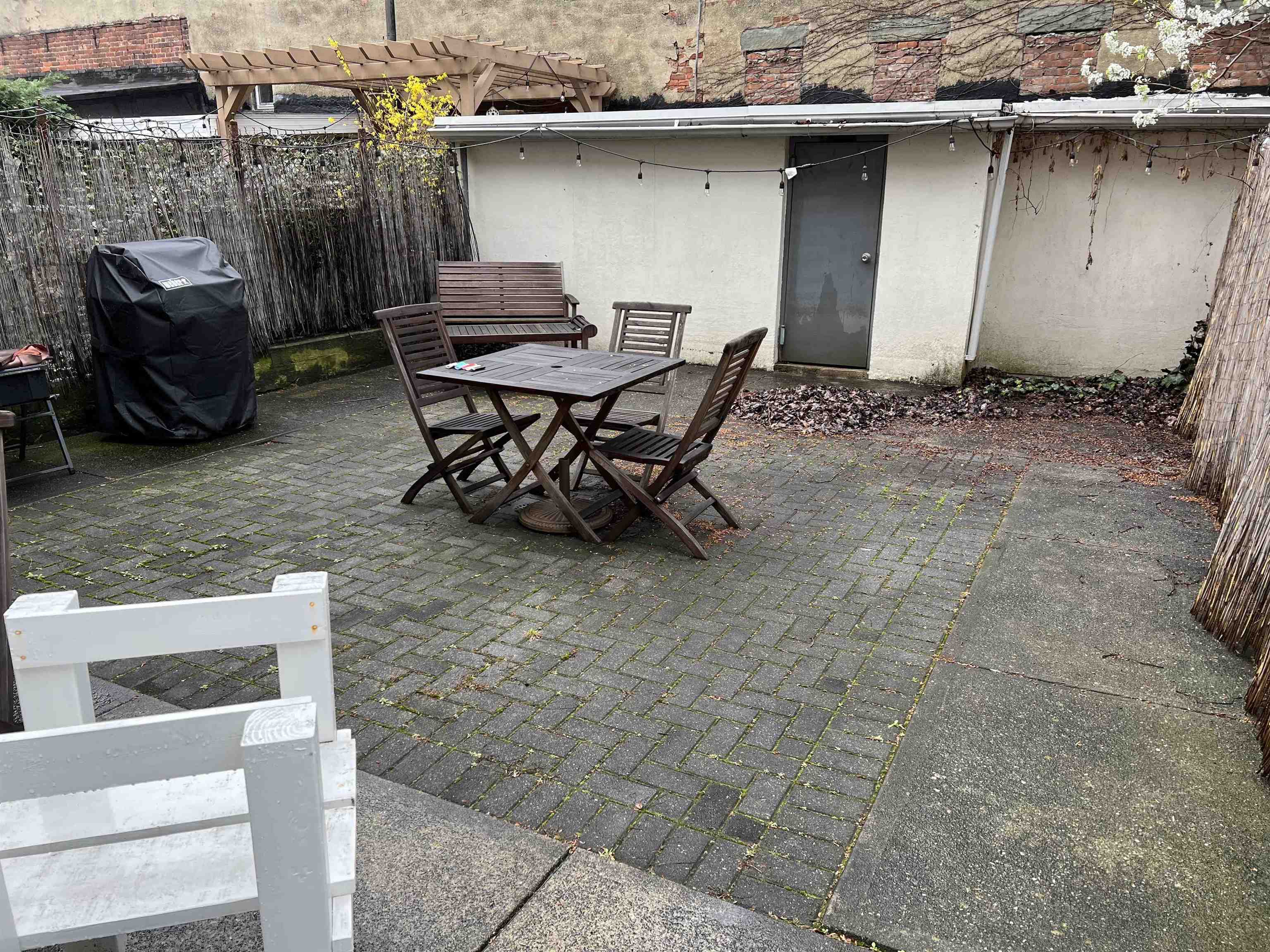 528 Garden Street, Unit B Hoboken, NJ 07030 - Photo 12 of 13 a backyard of a house with barbeque oven table and chairs