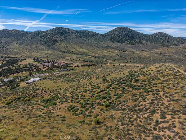 a view of a dry yard with mountains in the background