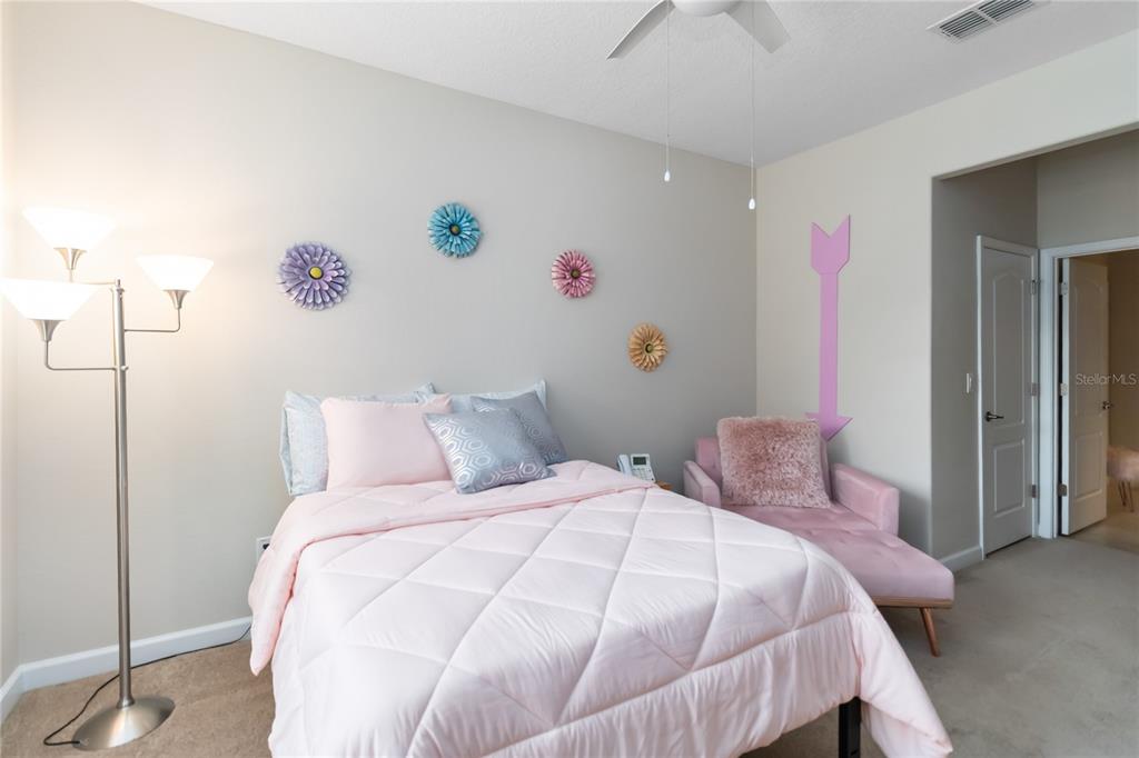 6805 Sundrop Street Harmony, FL 34773 - Photo 13 of 24 a bedroom with a bed and a wall painting