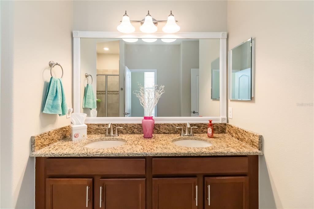 6805 Sundrop Street Harmony, FL 34773 - Photo 14 of 24 a bathroom with a granite countertop sink and a mirror