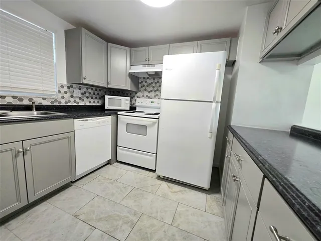 a white refrigerator freezer sitting inside of a kitchen