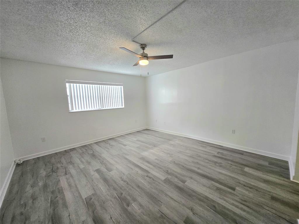 6503 Winfield Boulevard, Unit 107D Margate, FL 33063 - Photo 12 of 24 wooden floor in an empty room with a window