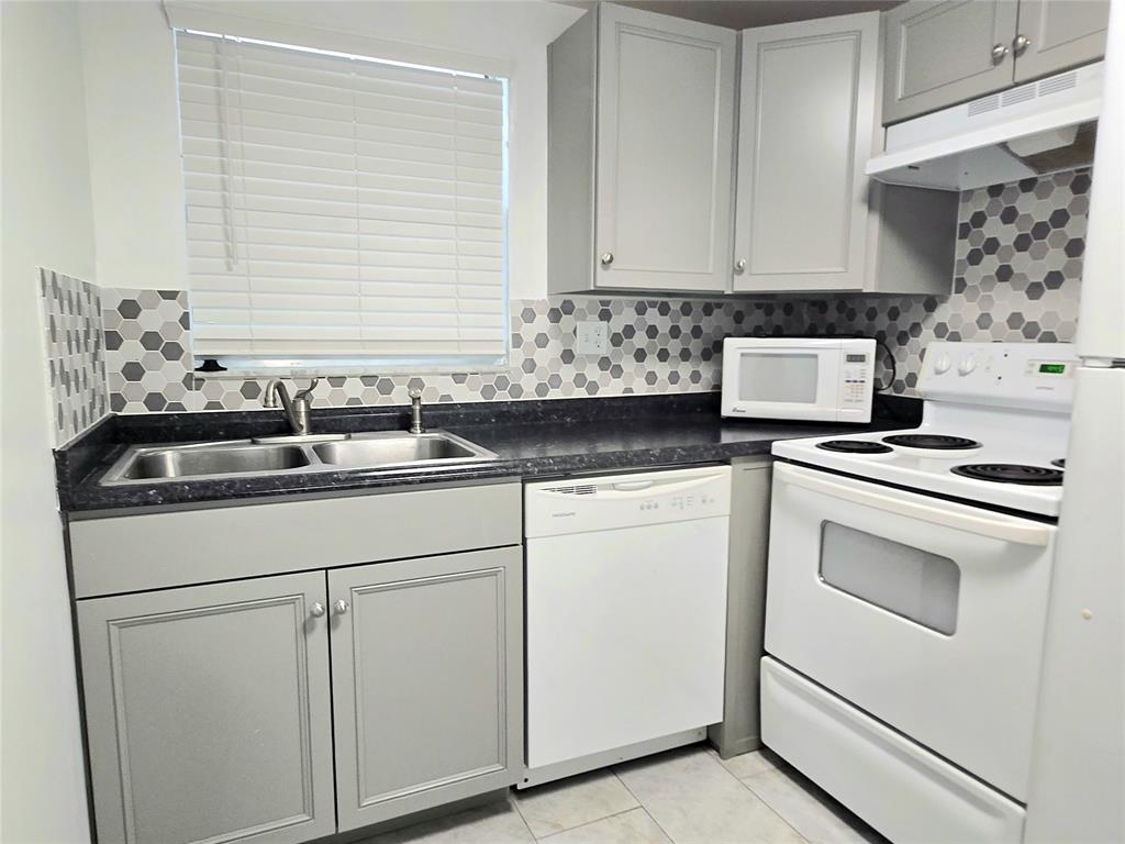 6503 Winfield Boulevard, Unit 107D Margate, FL 33063 - Photo 2 of 24 a kitchen with white cabinets and white appliances