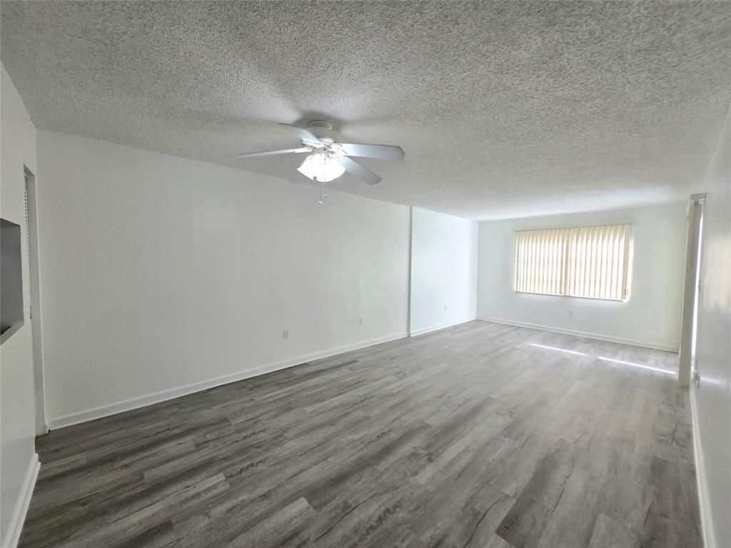 6503 Winfield Boulevard, Unit 107D Margate, FL 33063 - Photo 5 of 24 a view of empty room with wooden floor and fan