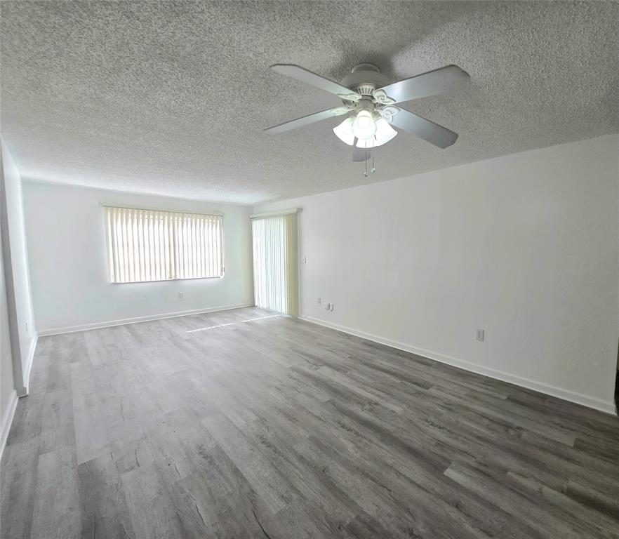 6503 Winfield Boulevard, Unit 107D Margate, FL 33063 - Photo 6 of 24 a view of an empty room with wooden floor and a window