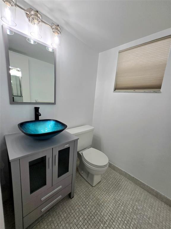 6503 Winfield Boulevard, Unit 107D Margate, FL 33063 - Photo 8 of 24 a bathroom with a toilet a sink and mirror