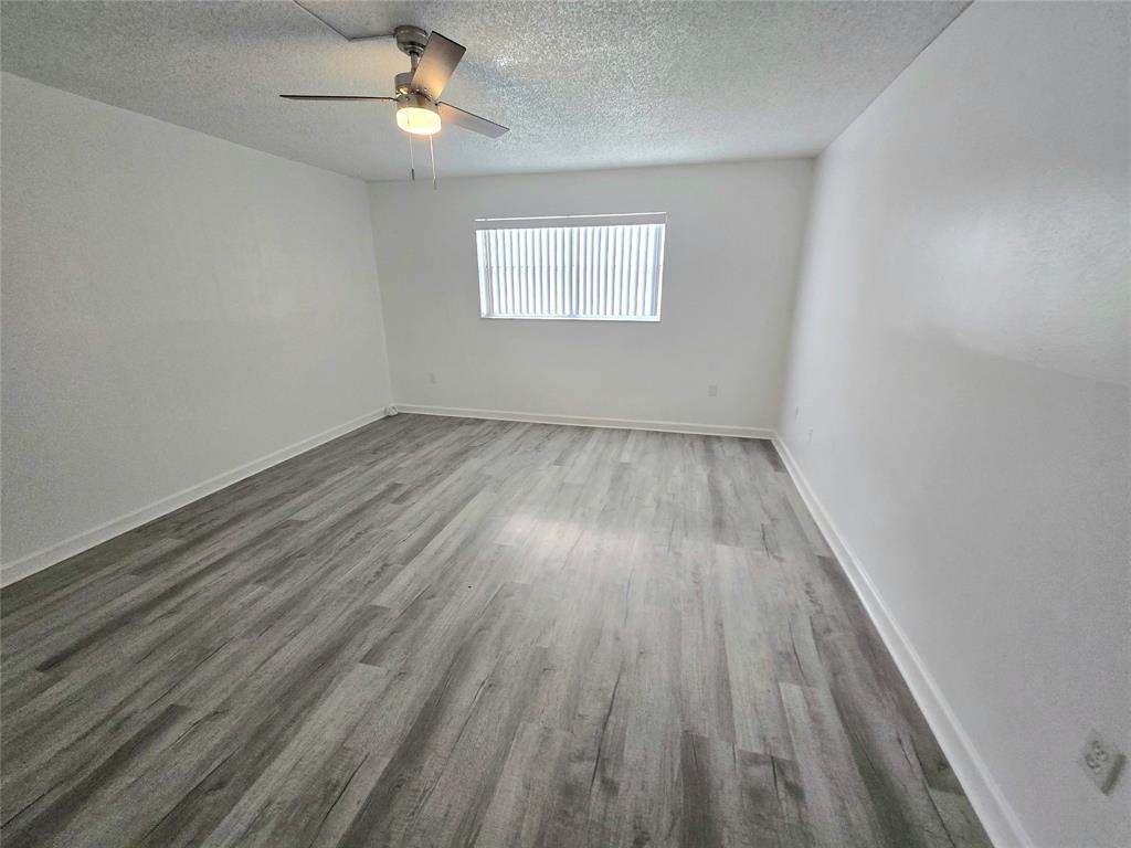 6503 Winfield Boulevard, Unit 107D Margate, FL 33063 - Photo 10 of 24 wooden floor in an empty room with a window