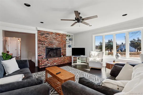 a living room with furniture a flat screen tv and a large window