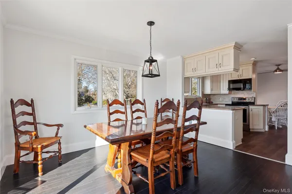 a dining room with furniture a chandelier and wooden floor