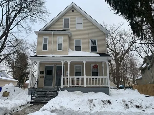 a front view of a house with a yard covered in snow
