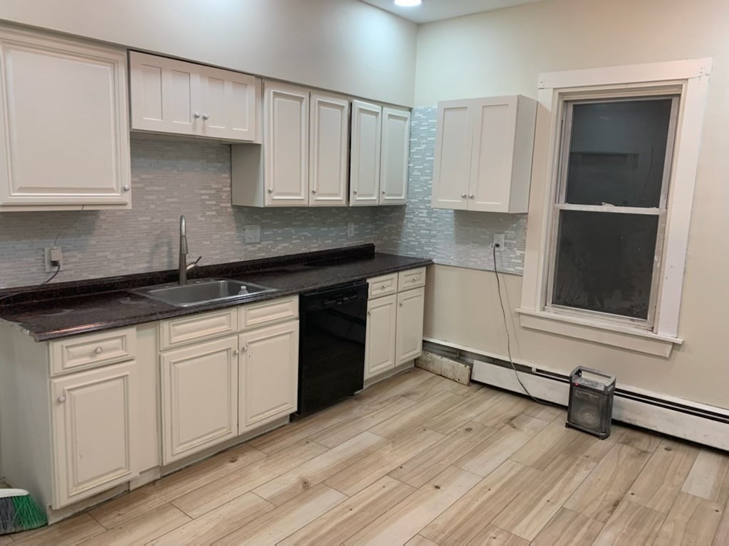 10 Bryant Street, Unit 2 Taunton, MA 02780 - Photo 2 of 8 a kitchen with granite countertop white cabinets and sink