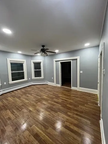 a view of an empty room with closet and a window