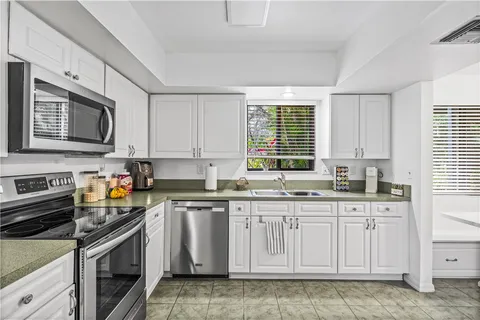a kitchen with stainless steel appliances granite countertop a stove a sink and a microwave