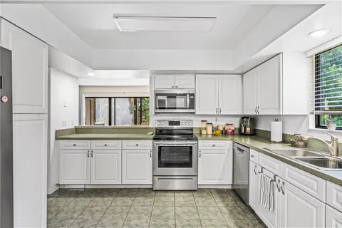 a kitchen with stainless steel appliances granite countertop a stove sink and cabinets