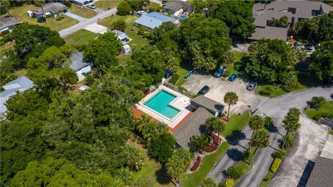 a view of a backyard with swimming pool and sitting area
