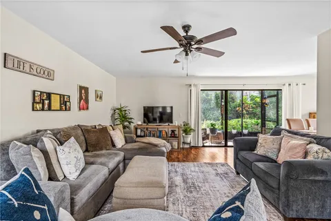 a living room with furniture wooden floor and a large window