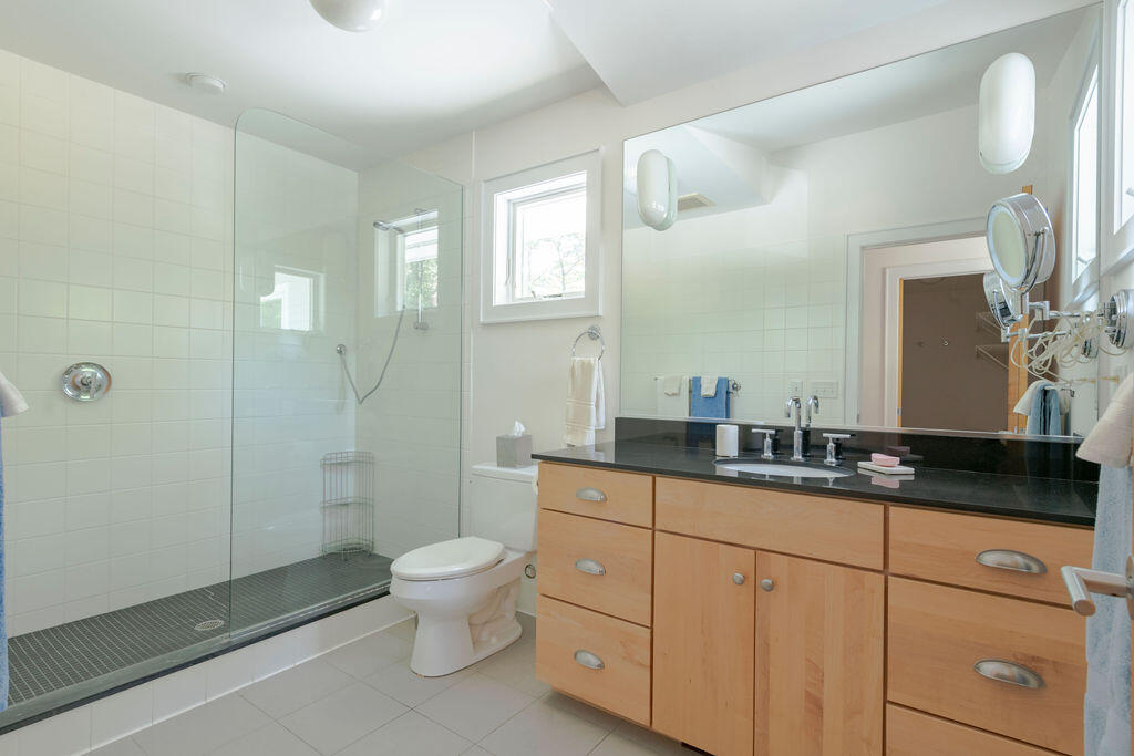 10 Hamblen Farm Road Wellfleet, MA 02667 - Photo 20 of 59 a spacious bathroom with a granite countertop sink a toilet a mirror and a shower