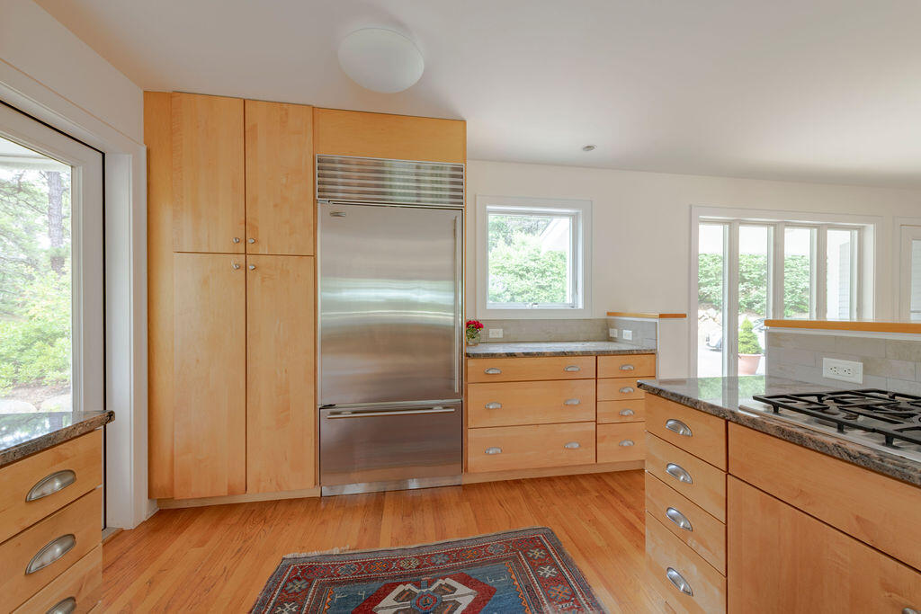 10 Hamblen Farm Road Wellfleet, MA 02667 - Photo 8 of 59 a kitchen with granite countertop a refrigerator and wooden cabinets