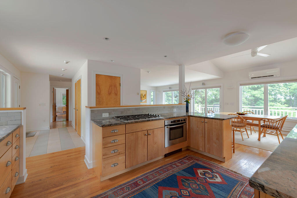10 Hamblen Farm Road Wellfleet, MA 02667 - Photo 10 of 59 a kitchen with granite countertop a stove top oven a sink dishwasher and wooden cabinets with wooden floor