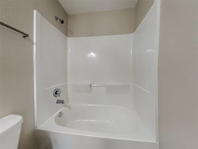 a white bath tub sitting next to a white toilet and sink