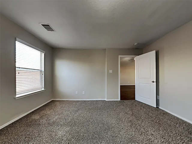 an empty room with closet and windows