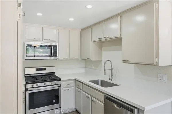 a kitchen with white cabinets stainless steel appliances and sink