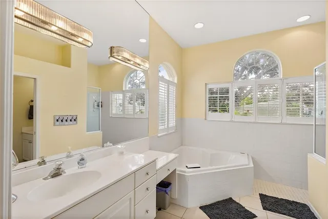 a bathroom with a tub sink and mirror