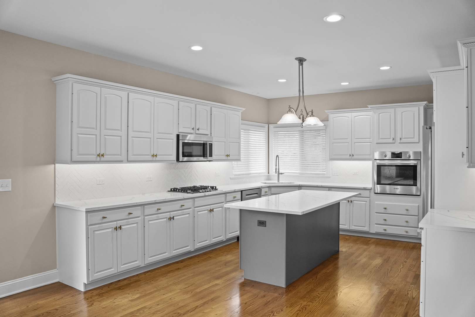 28798 Rivers Edge Drive Cary, IL 60013 - Photo 6 of 46 a kitchen with kitchen island granite countertop a sink cabinets and wooden floor