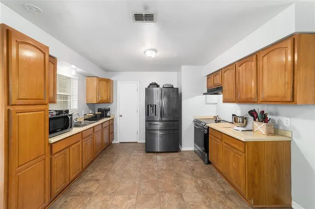 a kitchen with refrigerator and cabinets