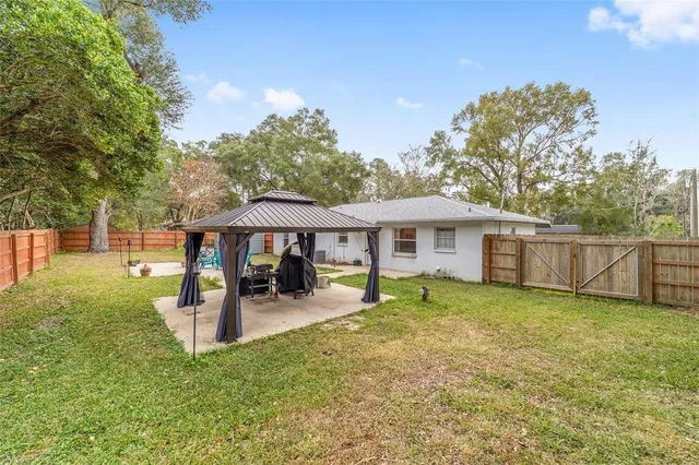 a backyard of a house with yard and trampoline
