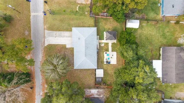 an aerial view of a house with a yard and large trees