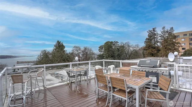 a view of a roof deck with table and chairs