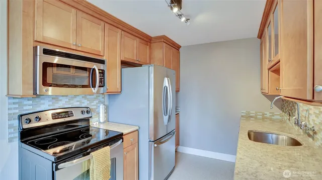 a kitchen with granite countertop a refrigerator stove and microwave