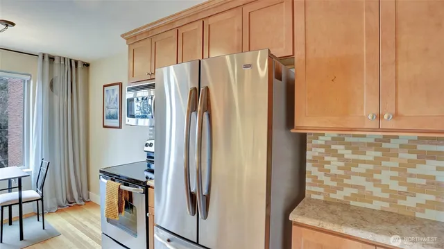 a kitchen with stainless steel appliances granite countertop a refrigerator and a stove