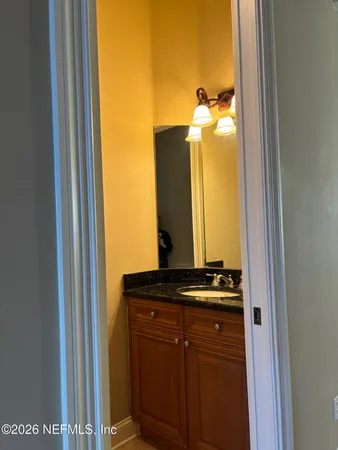 a bathroom with a granite countertop sink and a mirror