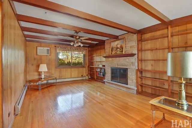 a view of a livingroom with wooden floor and a fireplace